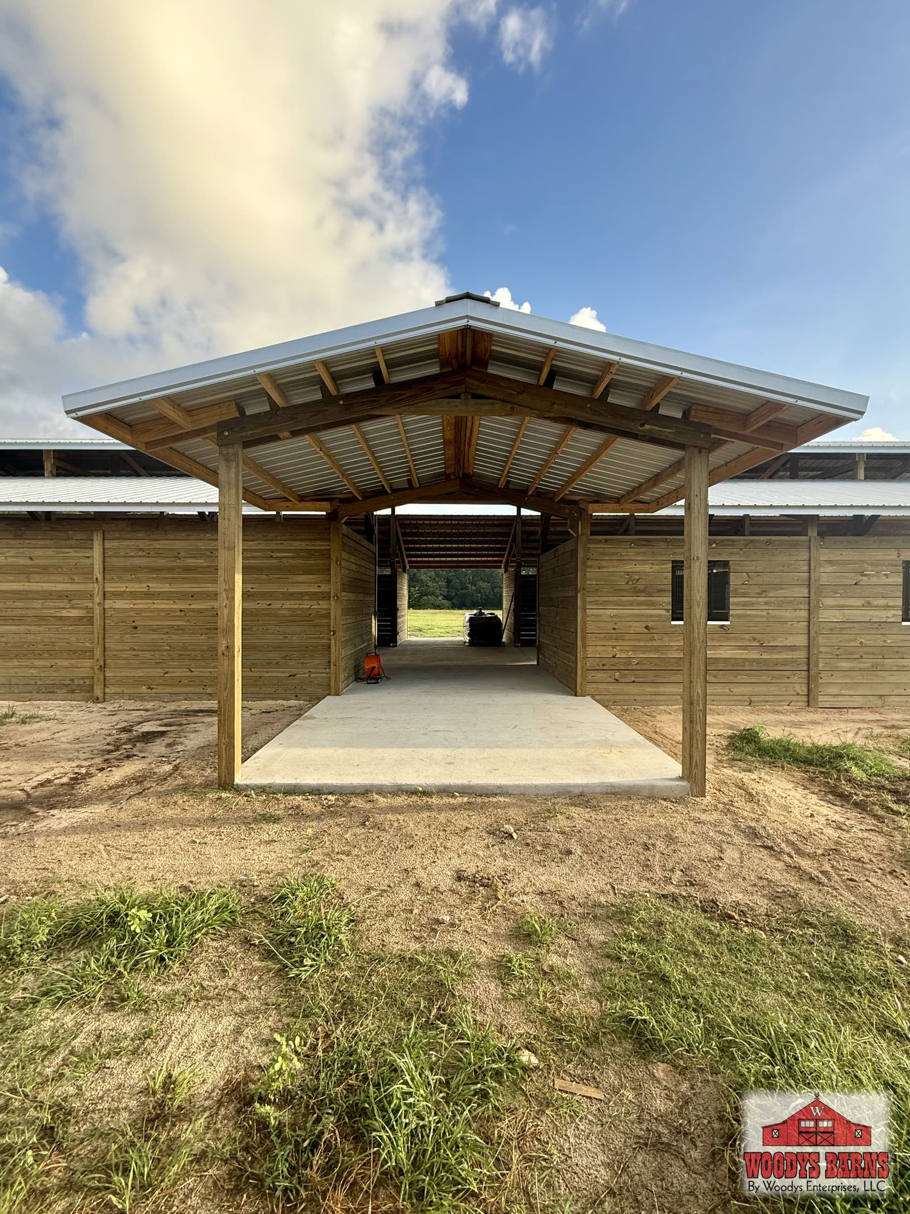 Center aisle breezeway with grilled stall fronts and daylight at both ends