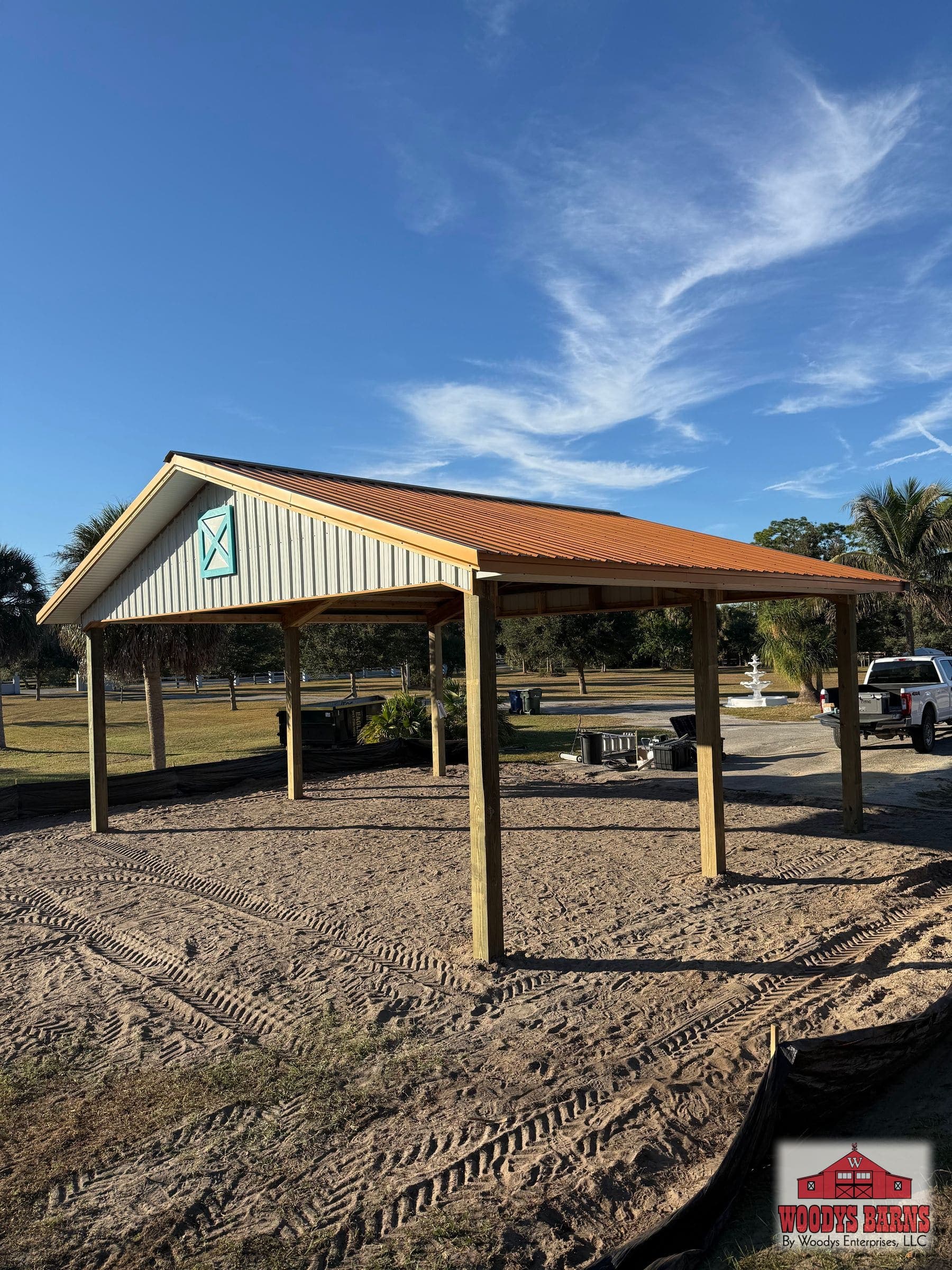 Open post frame pole barn with a copper metal roof and no walls, built by Woodys Barns in Florida