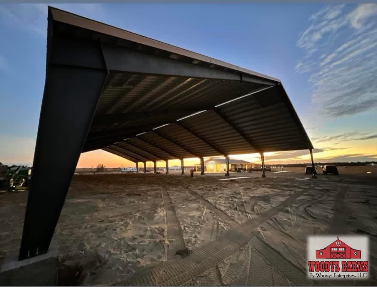 Clear span red iron arena frame at sunset