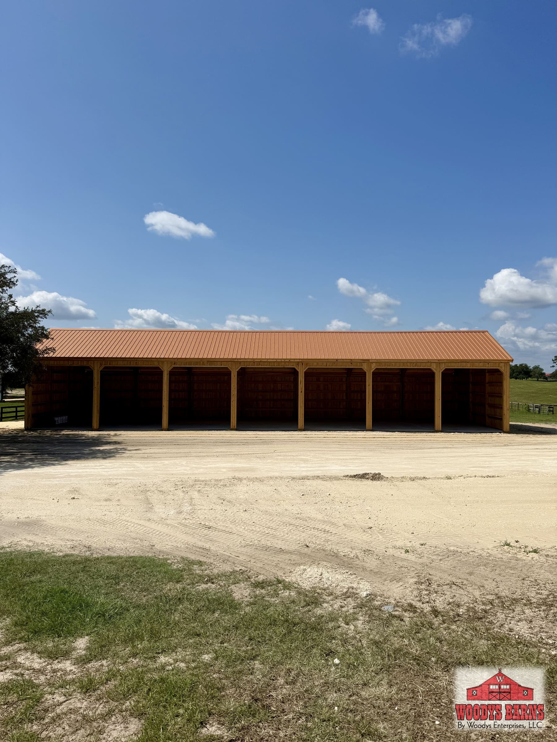Interior of a Woodys Barns build showing the engineered wood trusses and the continuous load path down to the slab