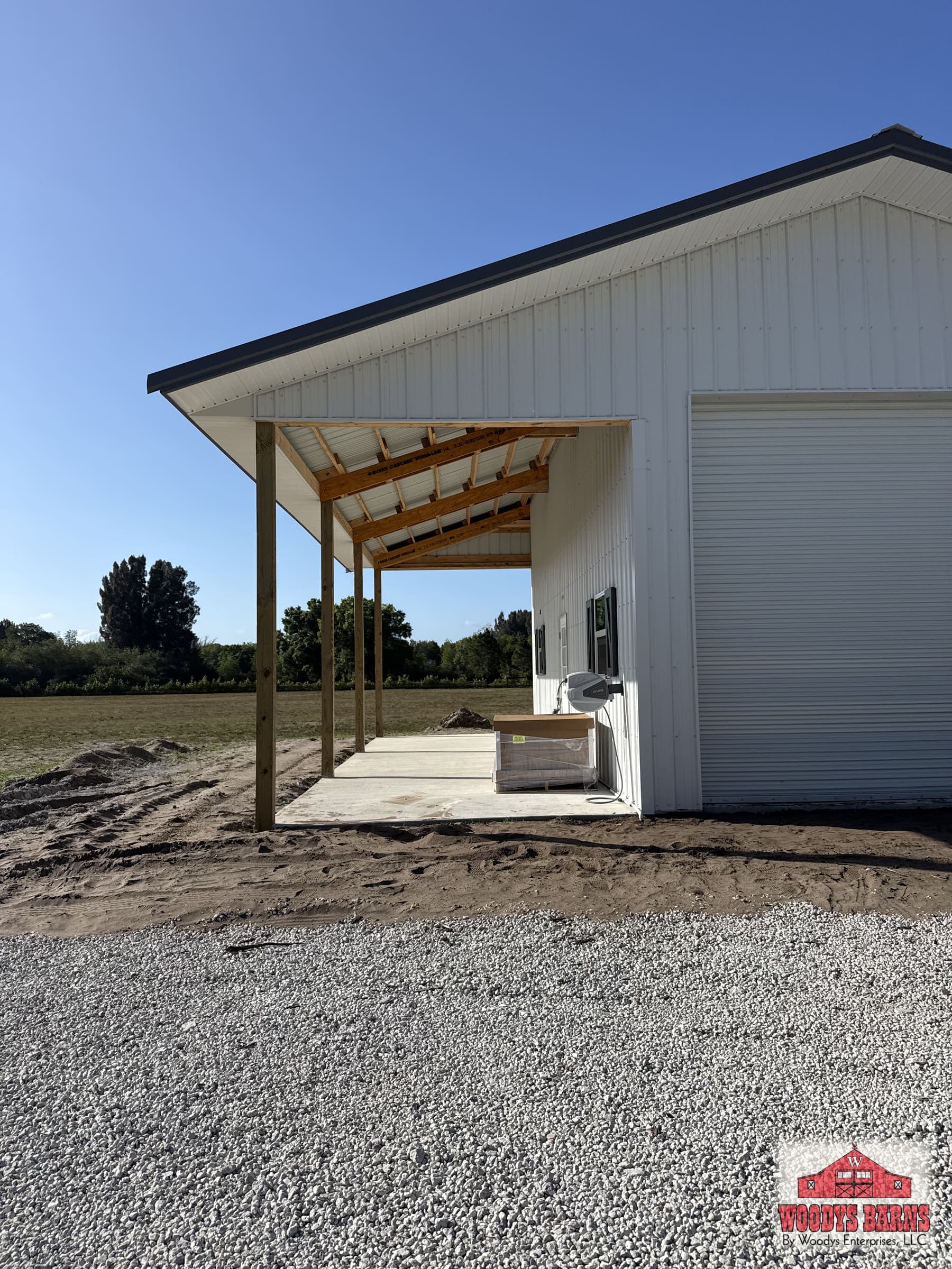 White metal garage with a roll up door and a covered lean to
