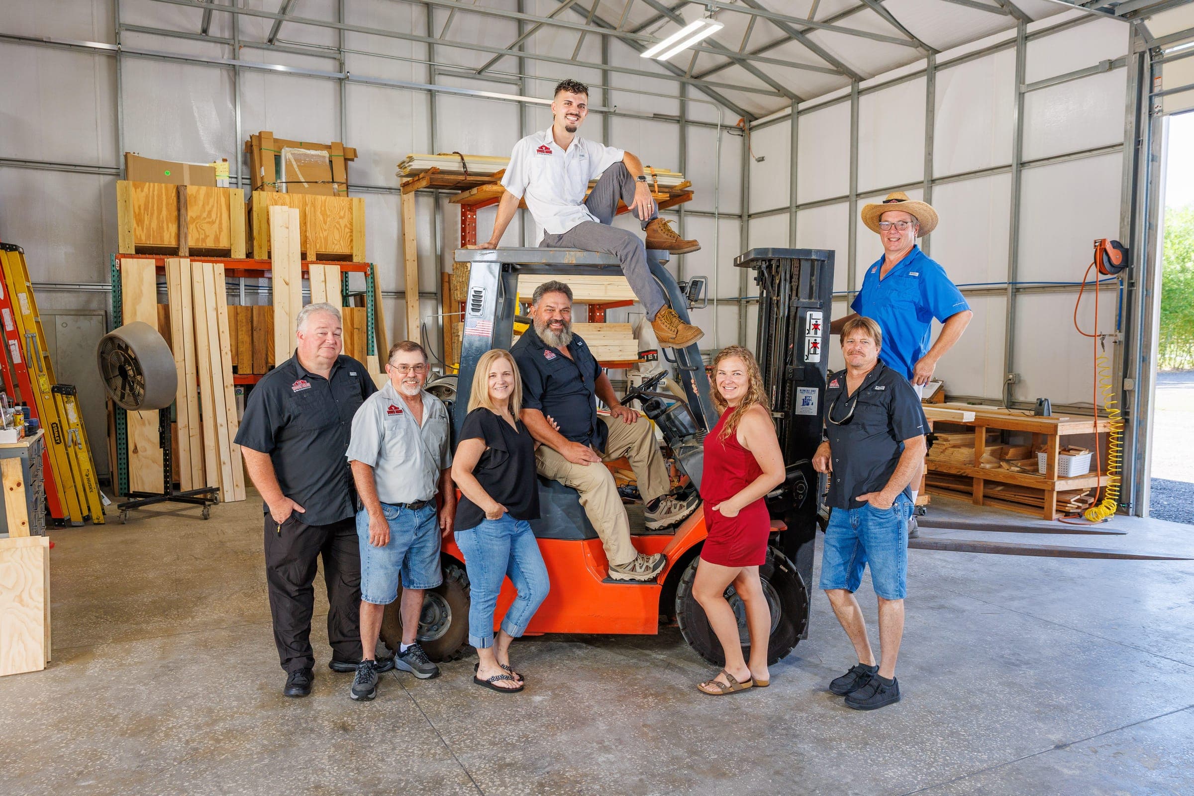 The Woodys Barns team in the warehouse, gathered around a forklift